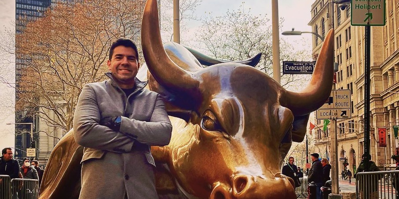 Ícaro Di Gaspare em frente ao touro de Wall Street, em Nova York